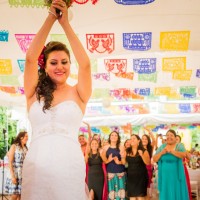 Adriana Lopez contenta en Oaxaca a punto de lanzar su ramo de flores a las novias.